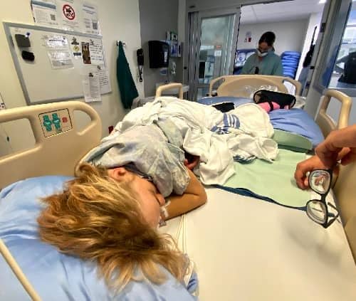 Scott lying in his hospital bed after surgery on his legs.